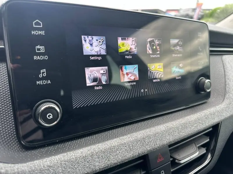 Écran tactile central de la Skoda Scala 2025 affichant le menu multimédia, avec commandes physiques sur le côté droit.