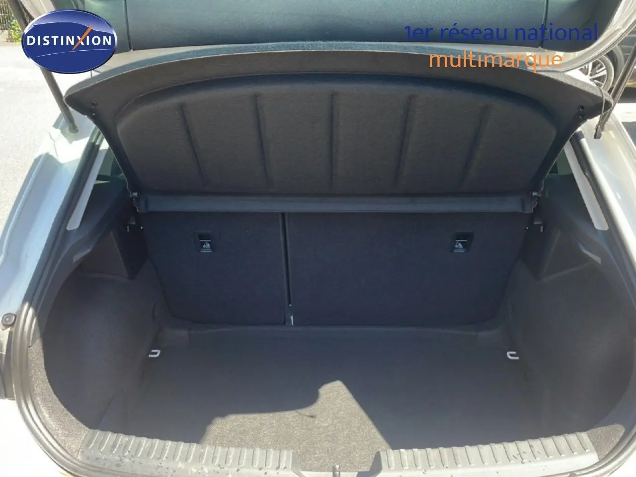Coffre ouvert vu de l'arrière d'une SEAT Leon blanche 2025, espace de chargement vide et propre.