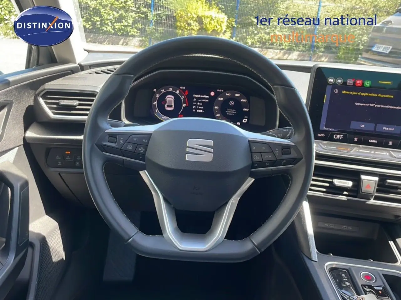 Vue intérieure centrée sur le volant multifonction d'une SEAT LEON 2025 avec tableau de bord numérique et écran tactile.