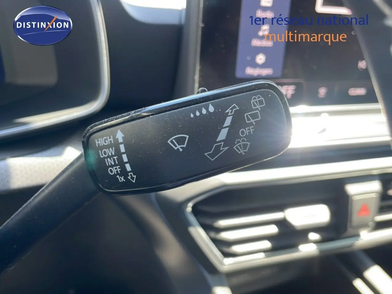 Gros plan sur la commande d’essuie-glace dans l’habitacle d’une SEAT LEON blanche, tableau de bord en arrière-plan flou.