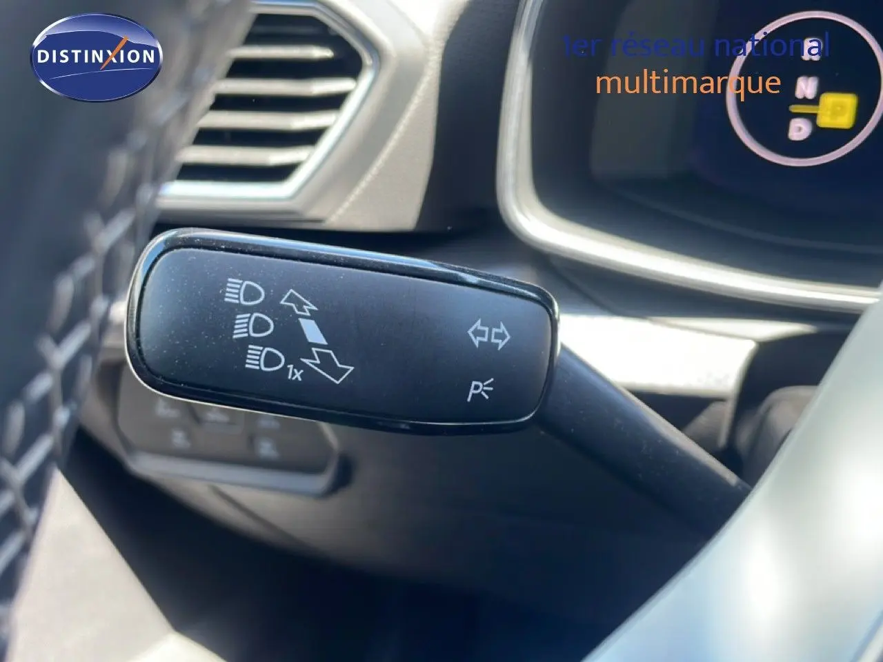 Gros plan sur la commande de clignotant et feux du tableau de bord d’un SEAT Leon blanc 2025, intérieur gris-noir.