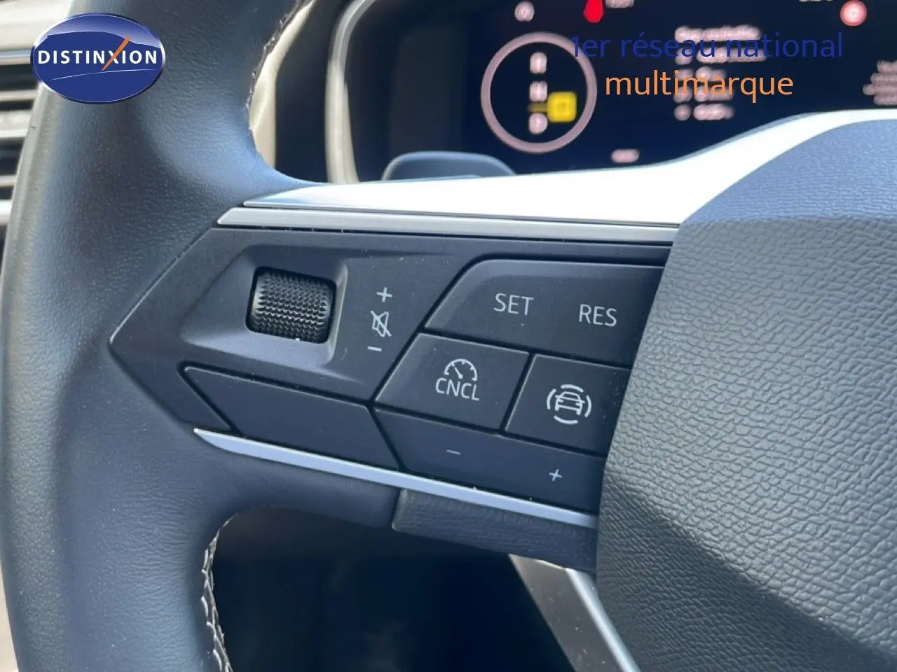 Gros plan sur les commandes au volant à gauche du SEAT LEON blanc 2025, avec régulateur de vitesse et boutons multifonctions.