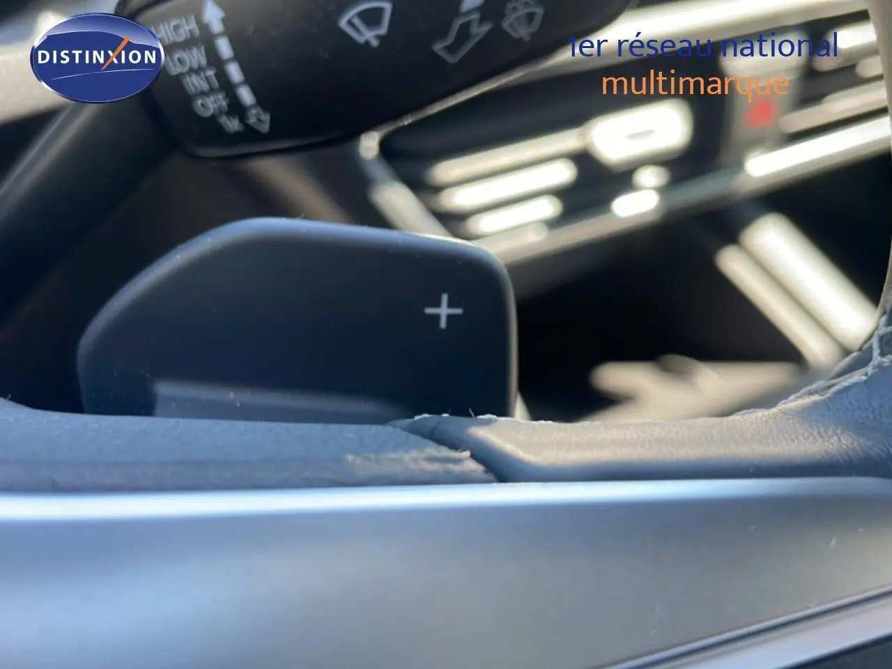 Gros plan sur la palette de changement de vitesse droite du volant d’une SEAT LEON blanche, intérieur gris-noir.