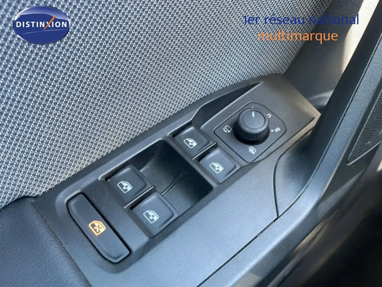 Gros plan sur les commandes de lève-vitres et rétroviseurs côté conducteur d'une SEAT LEON blanche 2025.