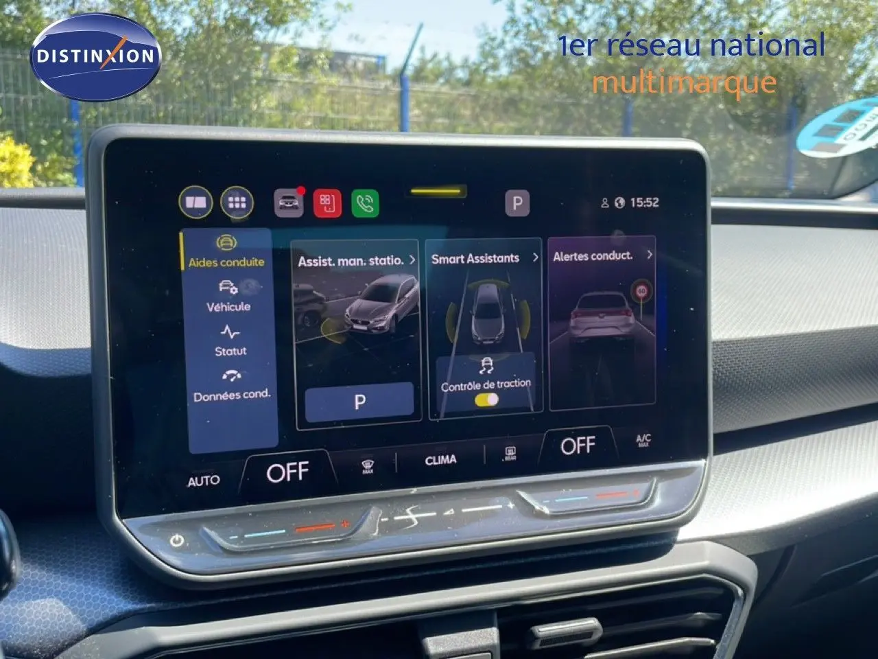 Vue intérieure du tableau de bord de la SEAT LEON blanc 2025, avec écran tactile central affichant les aides à la conduite.