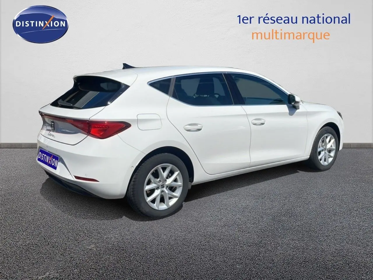 Vue 3/4 arrière droite d'une SEAT Leon blanche 2025 avec jantes alliage et vitres teintées.