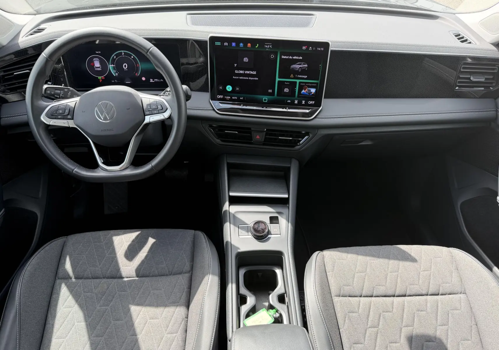 Vue intérieure avant du Volkswagen Tiguan 2025, tableau de bord noir avec écran tactile et volant multifonction cuir.