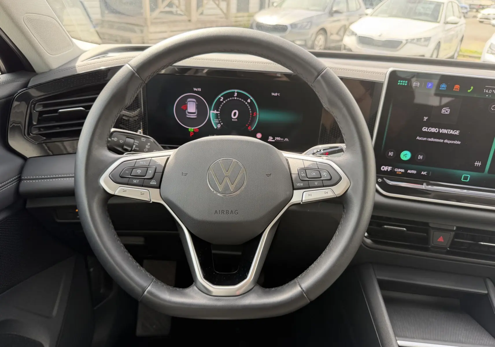 Vue intérieure centrée sur le volant cuir multifonction du Volkswagen Tiguan 2025 avec tableau de bord digital et écran tactile.