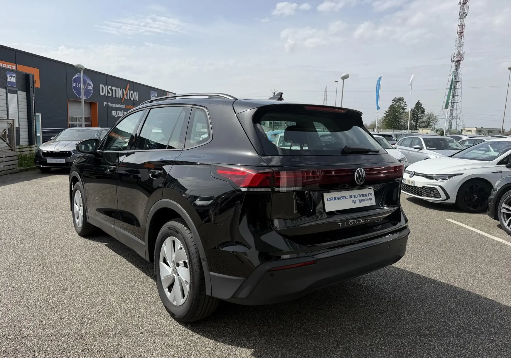 Vue 3/4 arrière droite d'un Volkswagen Tiguan noir 2025 avec feux arrière LED et jantes alliage 17 pouces.