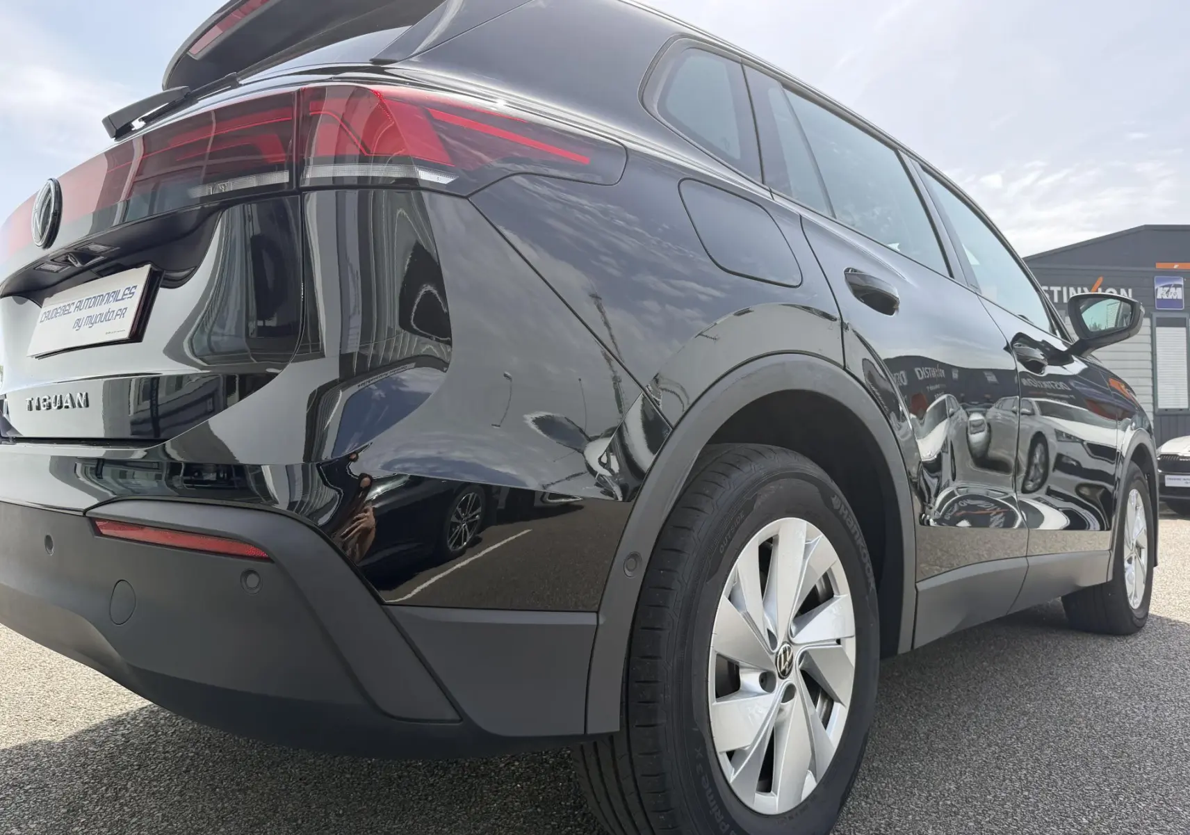 Vue 3/4 arrière droite du Volkswagen Tiguan noir 2025 avec jantes alliage 17 pouces et feux arrière LED distinctifs.