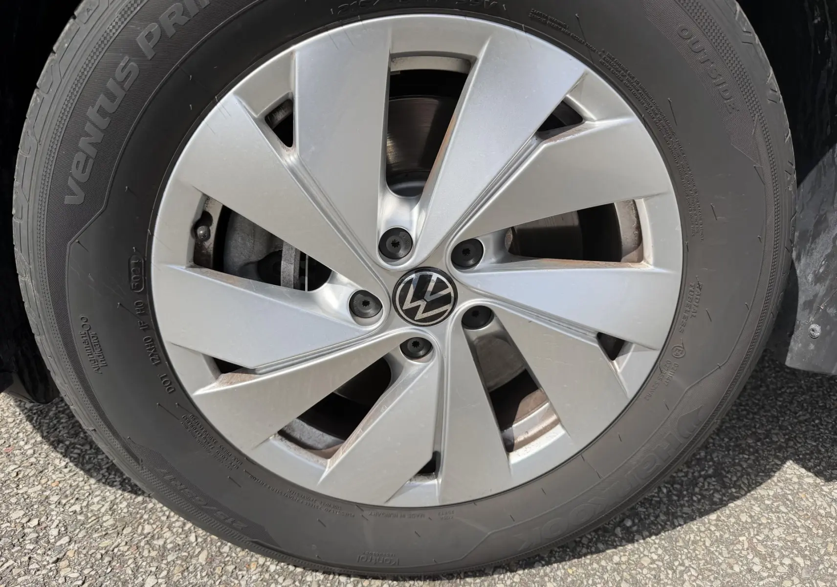 Gros plan sur la roue avant droite du Volkswagen Tiguan noir, jante alliage léger 17 pouces avec logo VW central.