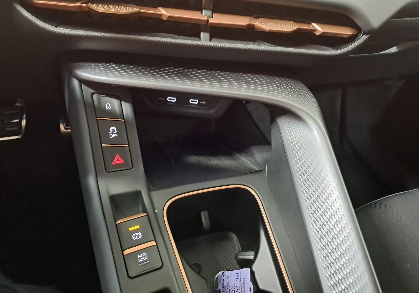 Gros plan sur la console centrale intérieure du CUPRA TERRAMAR avec détails en finition cuivre et boutons de contrôle.