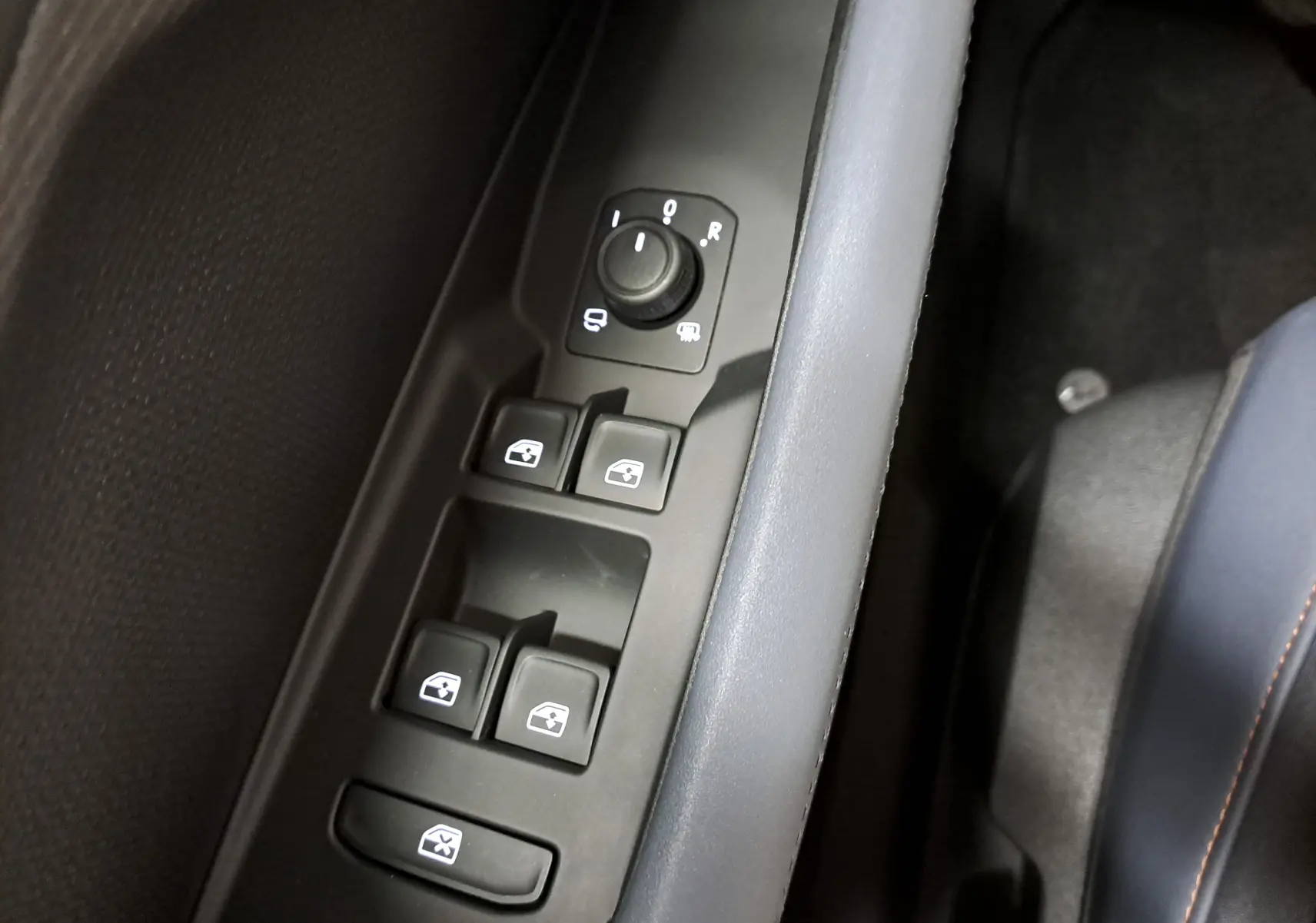Gros plan sur les commandes des vitres électriques et rétroviseurs côté conducteur du CUPRA TERRAMAR 2025, finition intérieure noire.