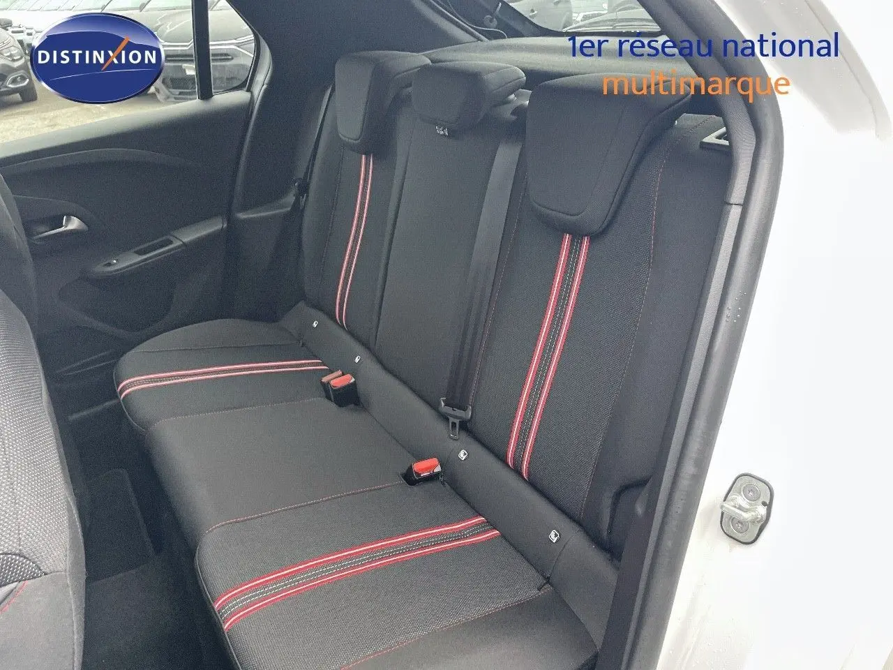 Vue intérieure côté droit des sièges arrière noirs avec surpiqûres rouges d'une Opel Corsa blanche 2022.