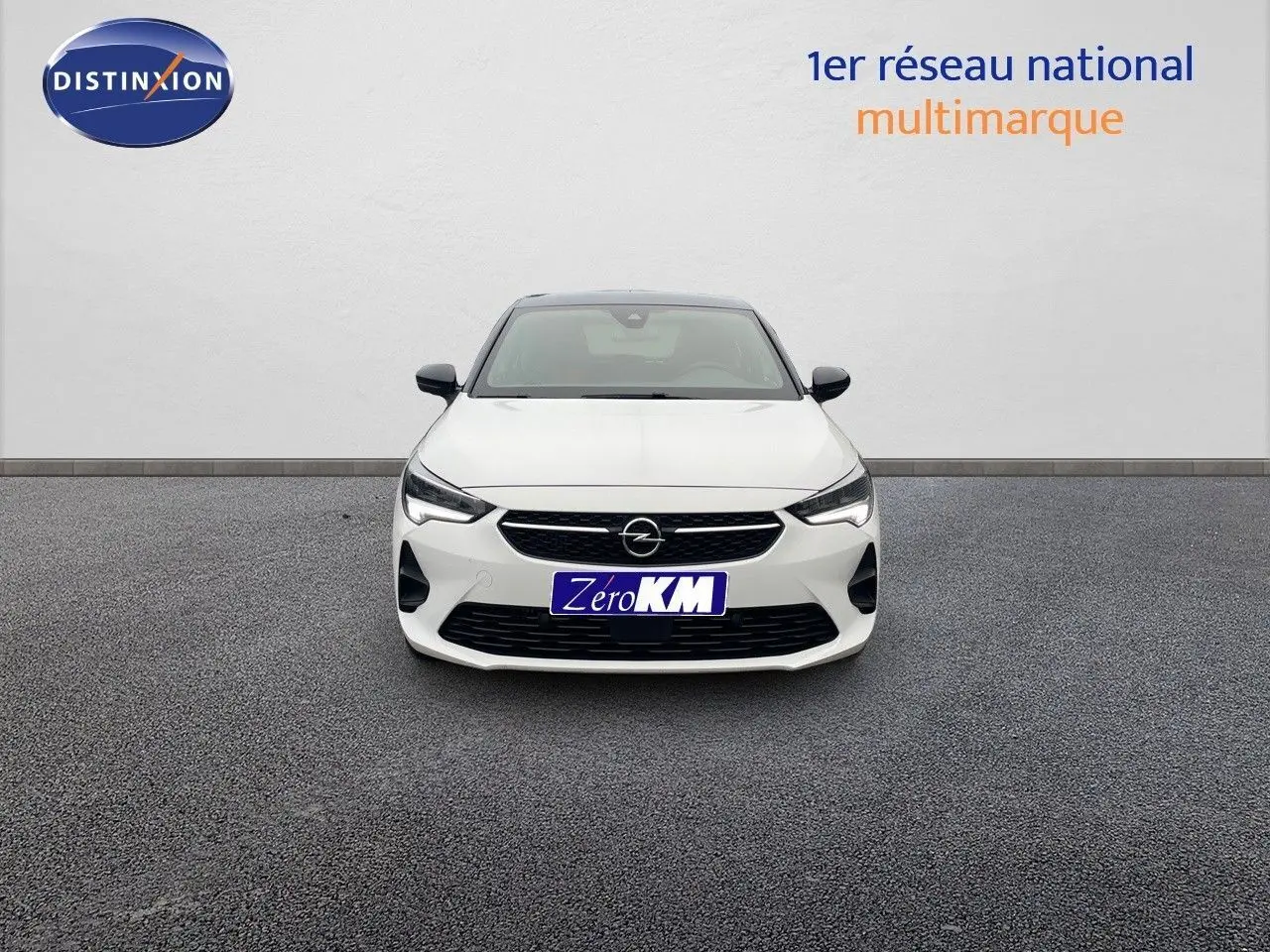 Vue frontale d'une Opel Corsa blanche 2022 avec calandre noire et phares LED allumés sur fond neutre.