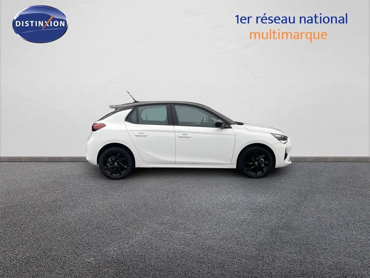 Profil droit d'une Opel Corsa blanche 5 portes avec jantes noires et toit contrasté noir sur fond neutre.