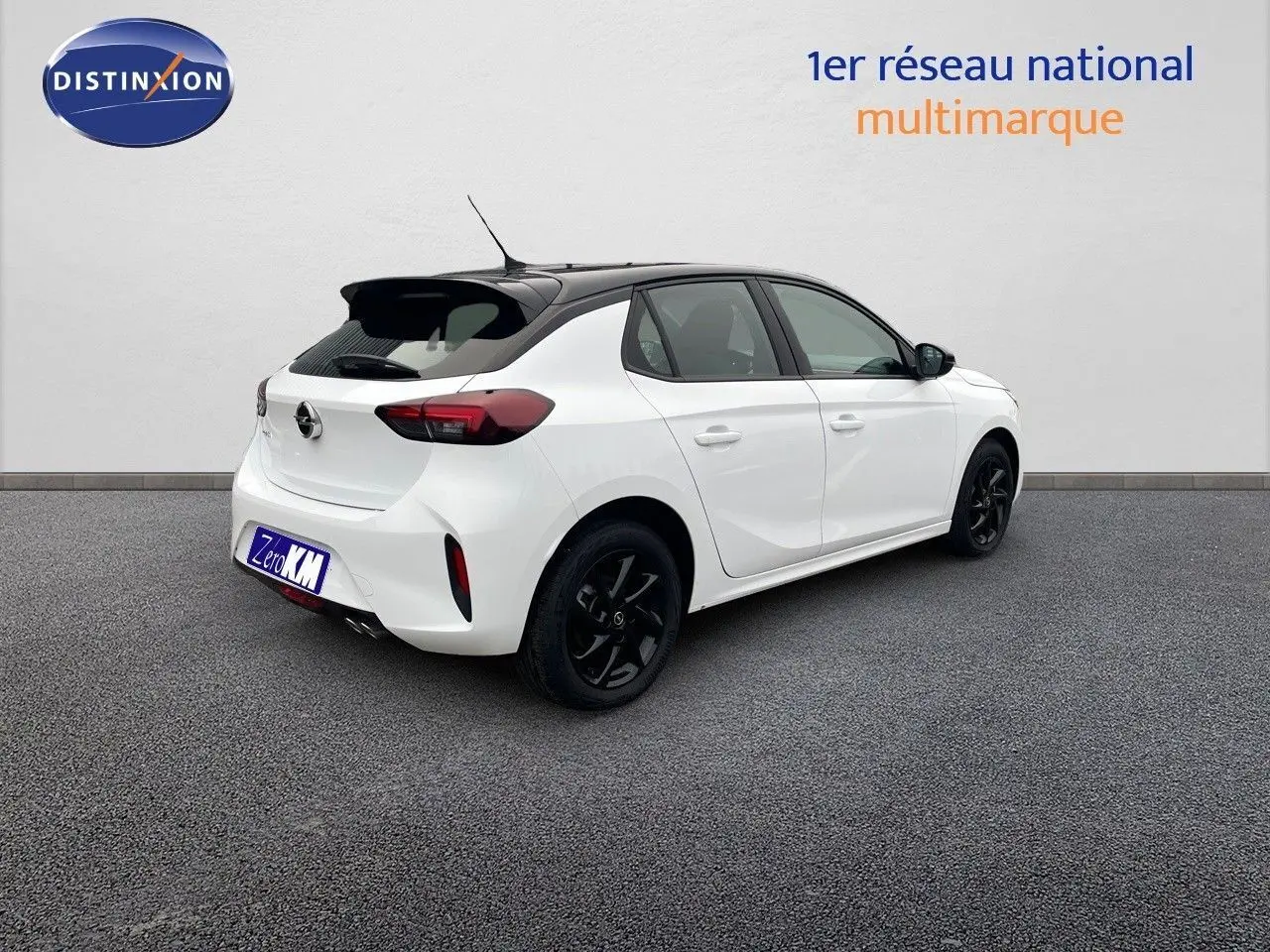 Vue 3/4 arrière droite d'une Opel Corsa blanche avec toit noir et jantes noires sur fond neutre.