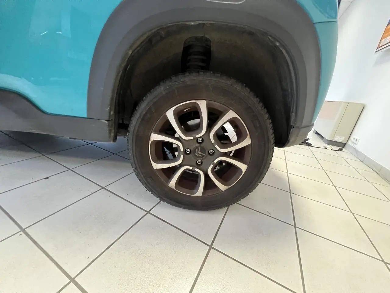 Gros plan sur la roue arrière droite d'une Citroën E-MEHARI cabriolet bleu clair avec jante alliage 15 pouces.