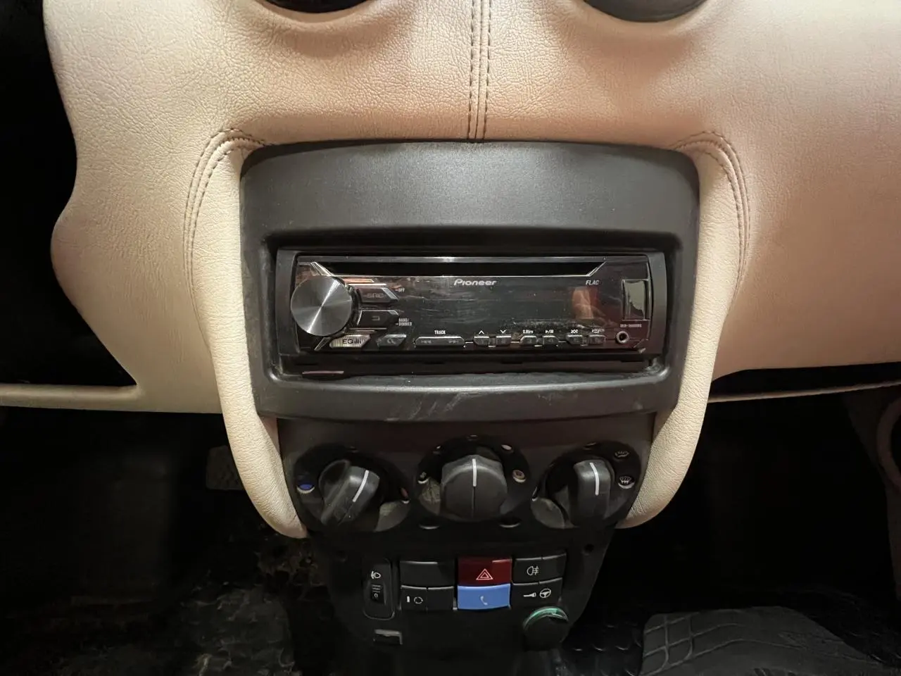 Vue rapprochée de la console centrale beige du Citroën E-MEHARI cabriolet 2016 avec autoradio Pioneer et commandes de climatisation.