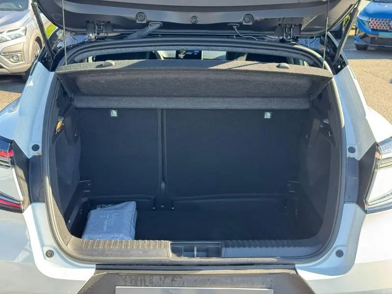 Coffre ouvert en vue arrière d'un Renault Captur 2025 noir, montrant l'espace de chargement et une trousse dans le coffre.