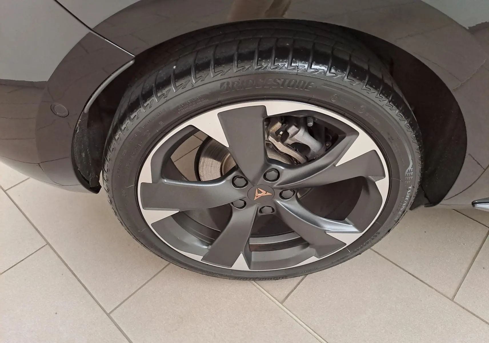 Gros plan sur la roue avant droite d'une CUPRA Leon Noir Minuit avec jante alliage au design moderne.