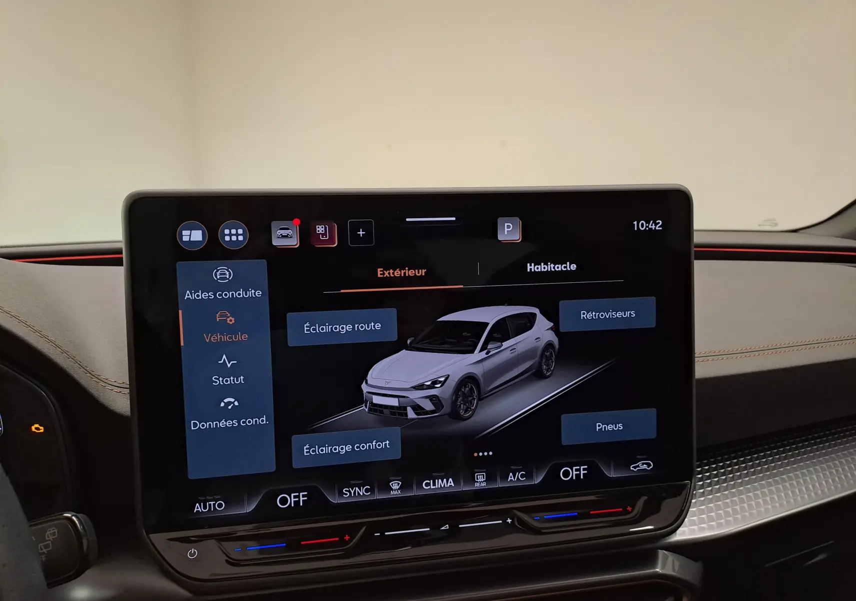 Écran tactile intérieur affichant une vue 3/4 avant d'une CUPRA Leon noire avec options d'éclairage et pneus.