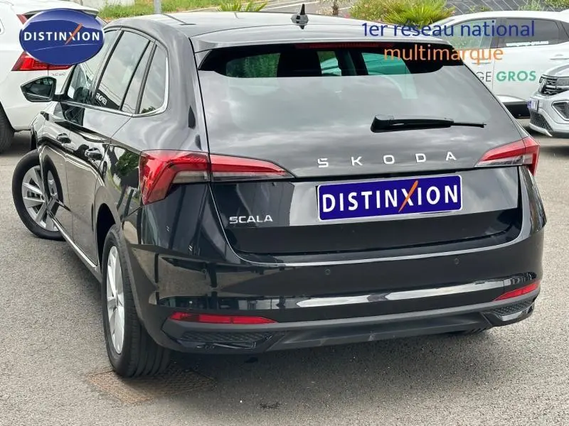 Vue 3/4 arrière droite d'une Skoda Scala noire Magic nacré avec feux arrière LED et jantes alu.