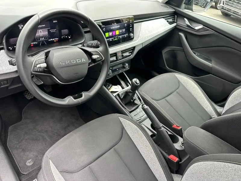 Vue intérieure côté conducteur de la Skoda Scala 2025, volant cuir multifonction et sièges tissu noir/gris.