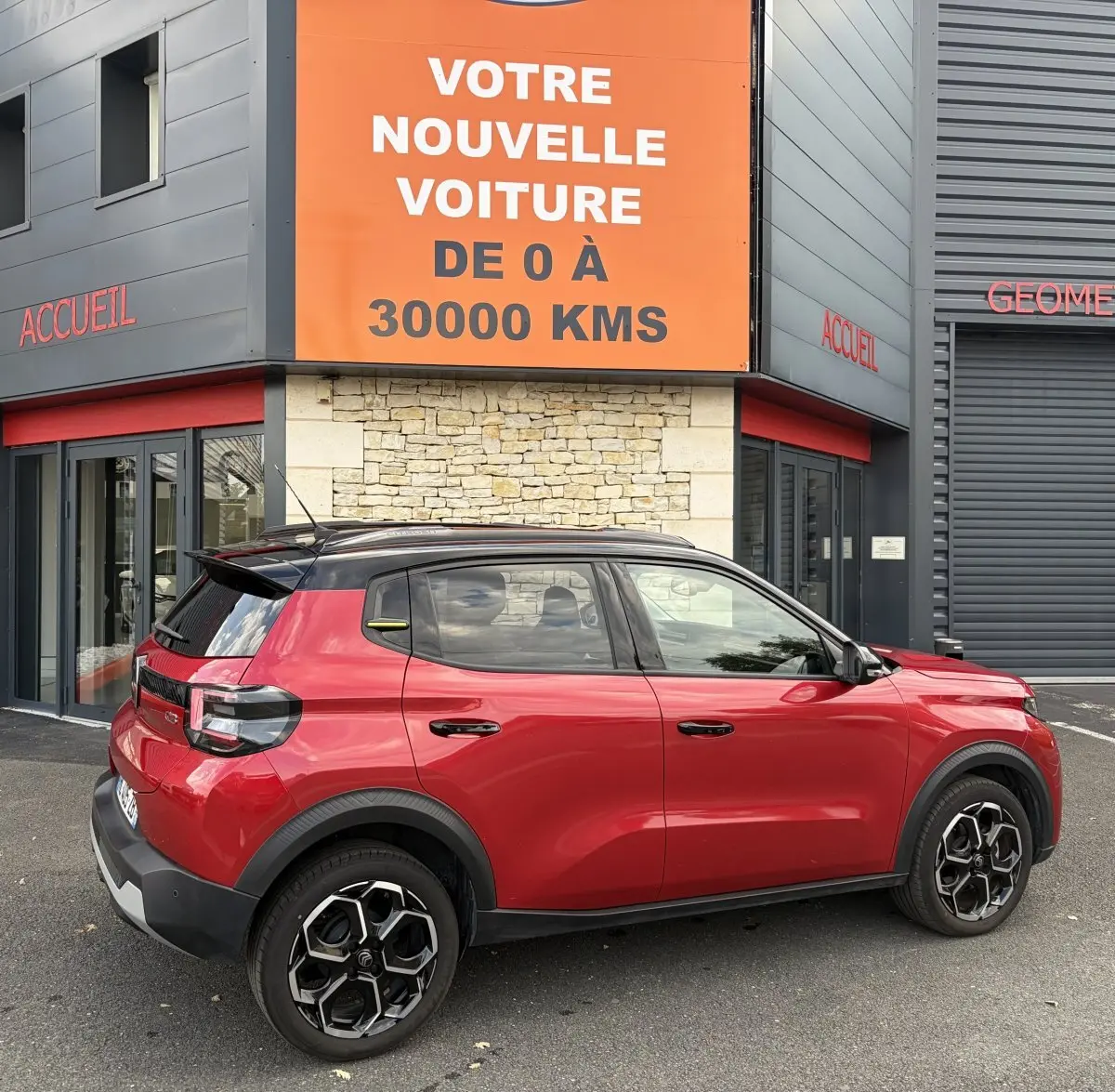 Vue latérale droite d'une Citroën C3 Turbo 100 BVM6 MAX rouge 2025 avec toit noir et jantes distinctives.