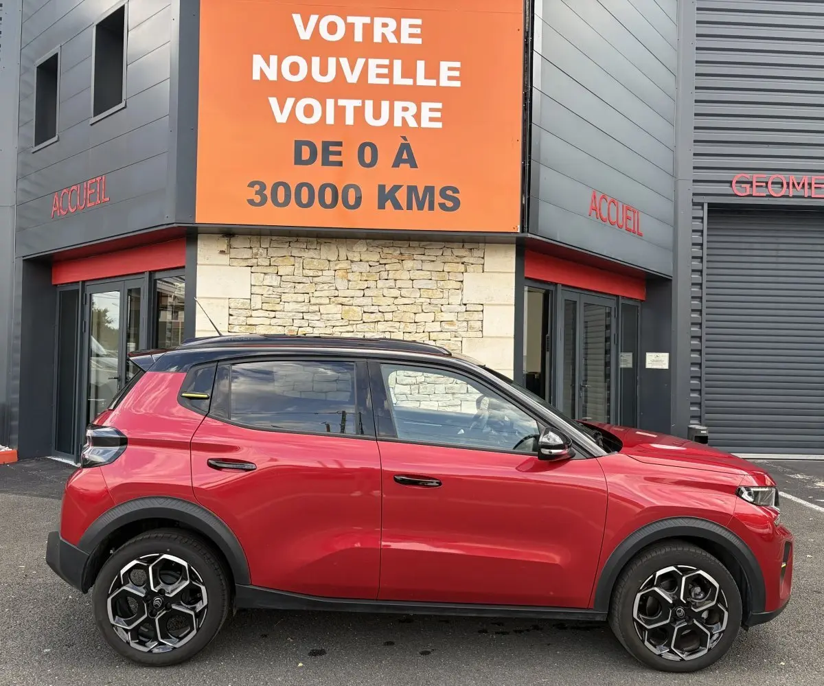 Profil droit d'une Citroën C3 Turbo 100 BVM6 MAX rouge 2025 avec toit noir et jantes alliage distinctives.