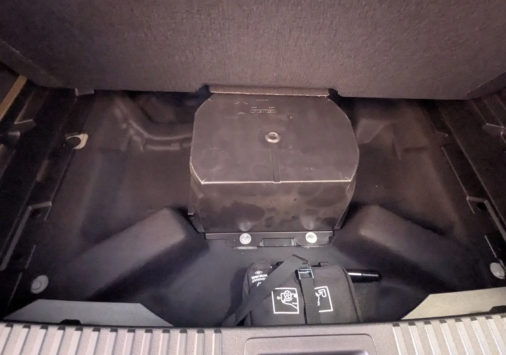 Coffre ouvert montrant le compartiment de rangement sous plancher d’un Renault Austral E-Tech gris, détail intérieur.