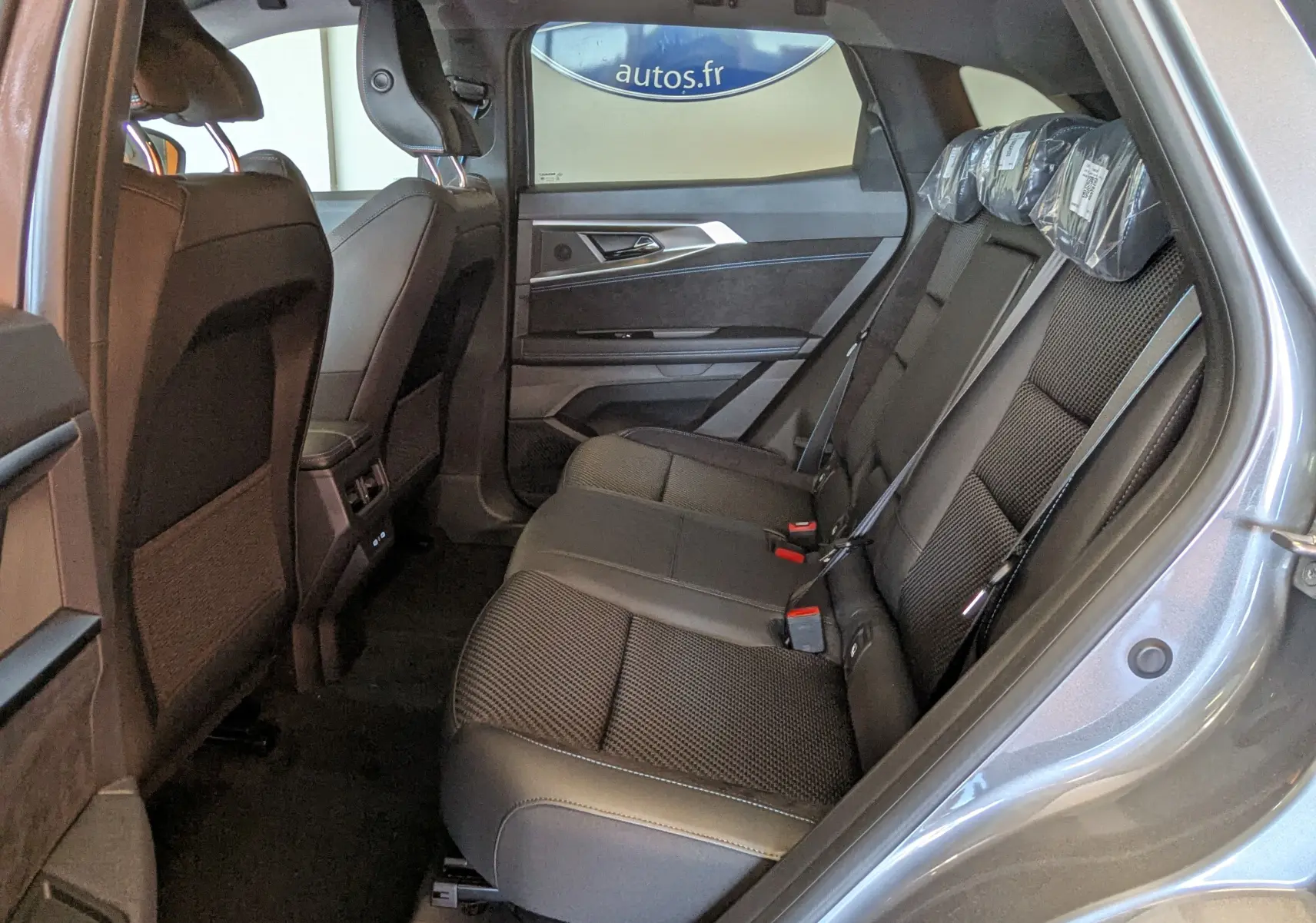 Vue latérale droite de l’habitacle arrière du Renault Austral E-Tech 200 Esprit Alpine, sièges en tissu noir.