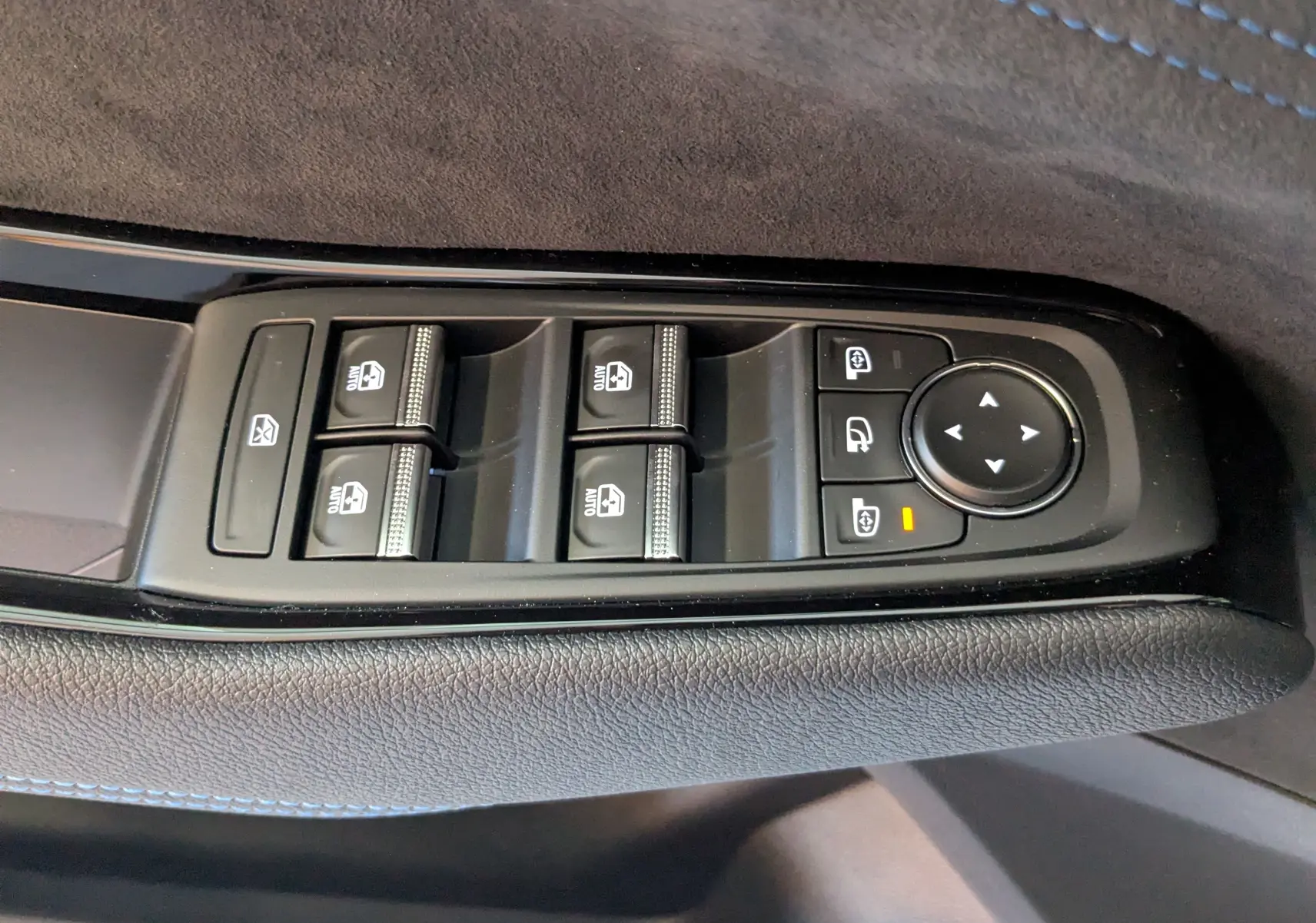 Gros plan sur les commandes de lève-vitres et réglage des rétroviseurs côté conducteur du Renault Austral E-Tech gris schiste.