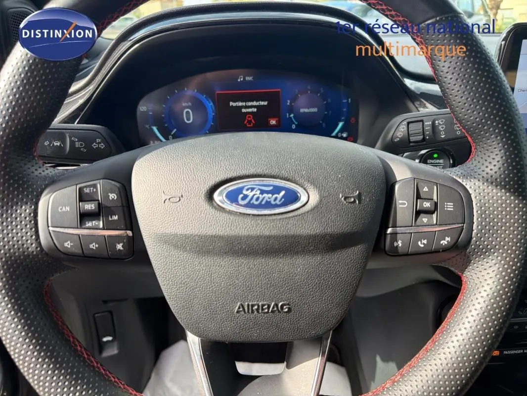 Vue rapprochée du volant perforé avec surpiqûres rouges du Ford Puma 2022, tableau de bord numérique visible.