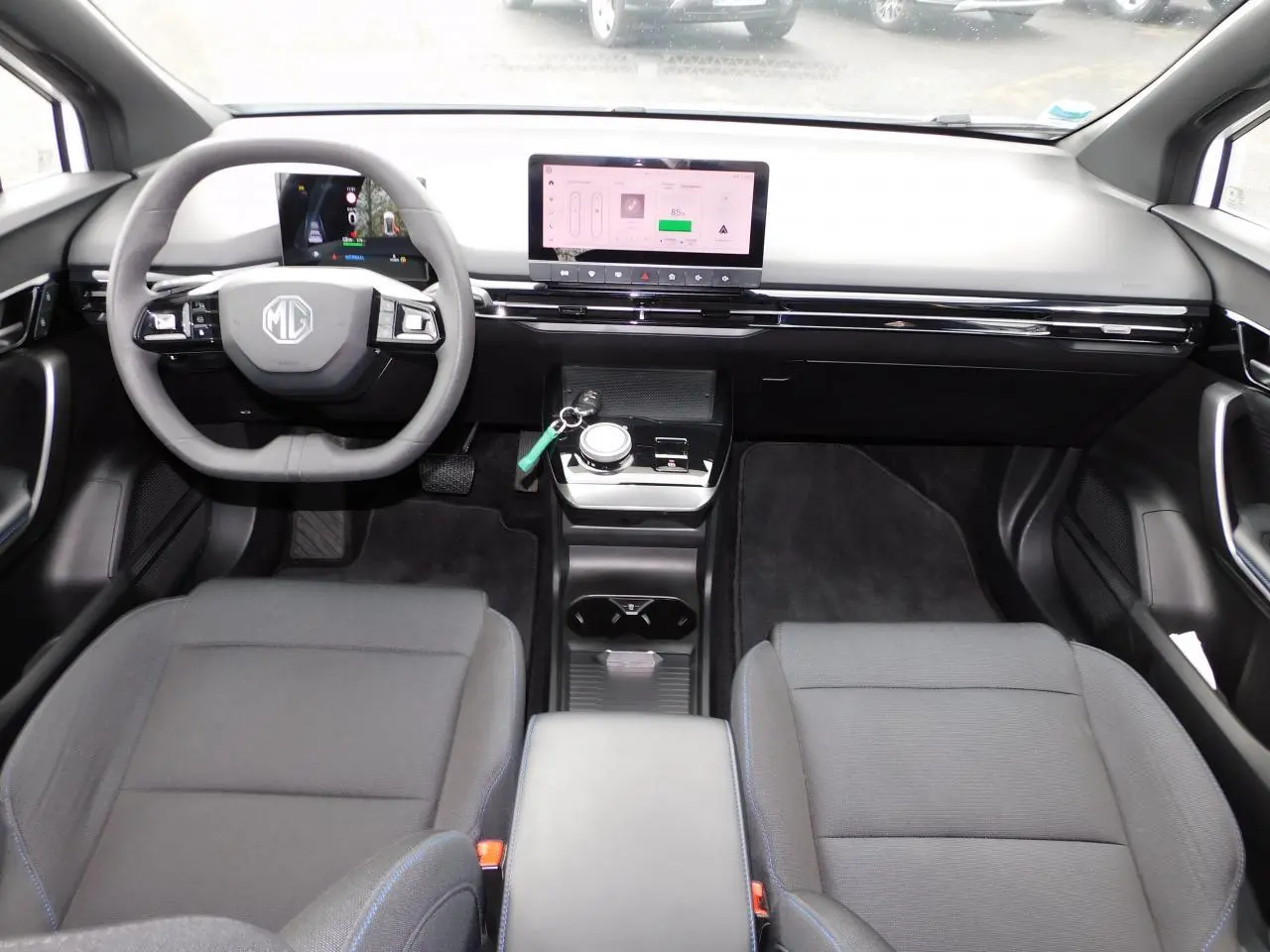 Intérieur avant du MG4 électrique 2023, vue depuis l'arrière, avec tableau de bord numérique et écran tactile central.