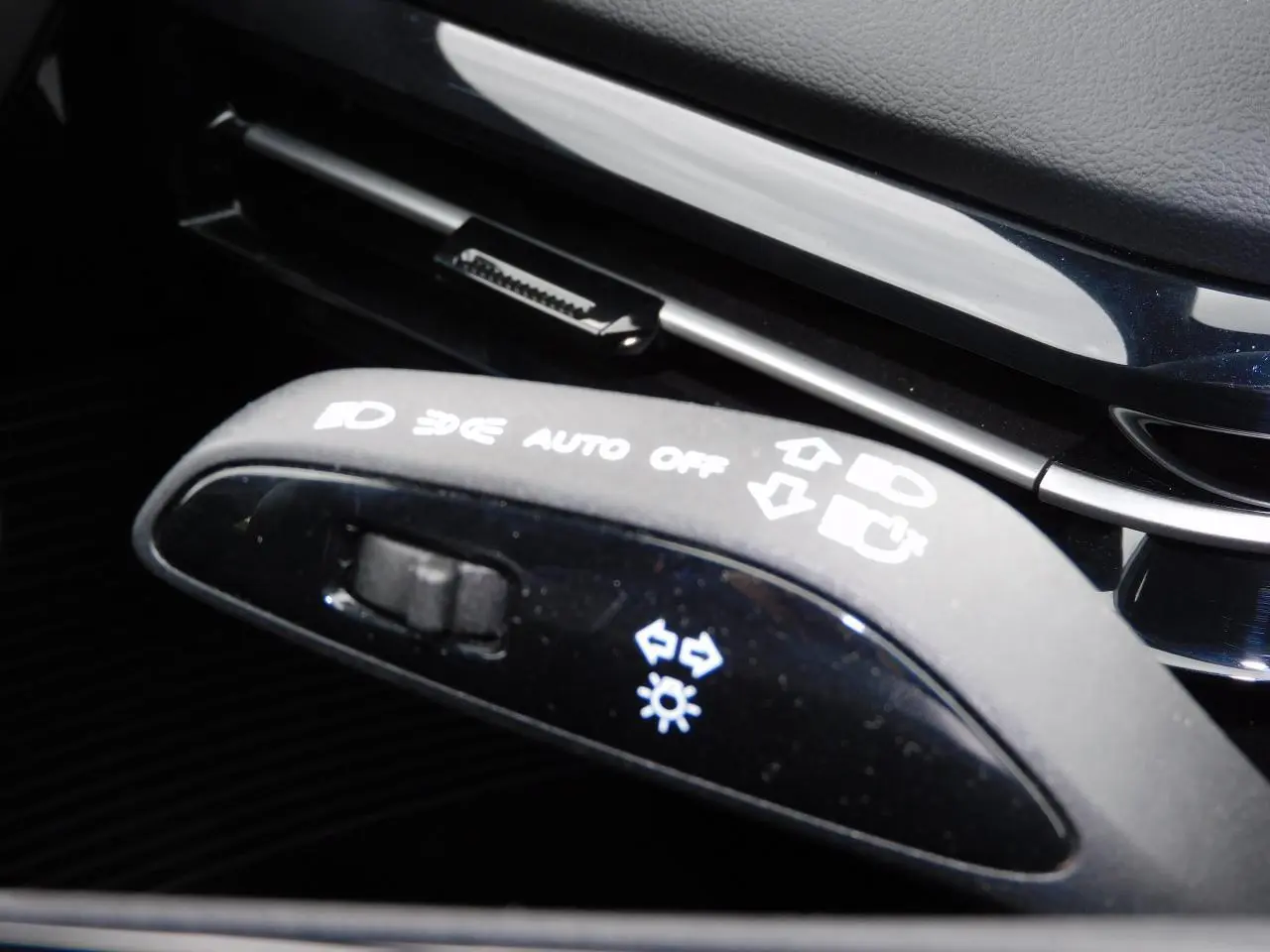 Gros plan sur la manette de commandes lumineuses noire dans l'habitacle du MG MOTOR MG4 blanc 2023.