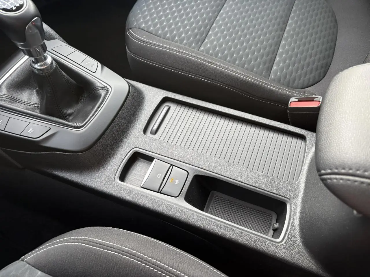 Vue rapprochée de la console centrale noire avec levier de vitesses manuelle et accoudoir du Ford Kuga 2024.