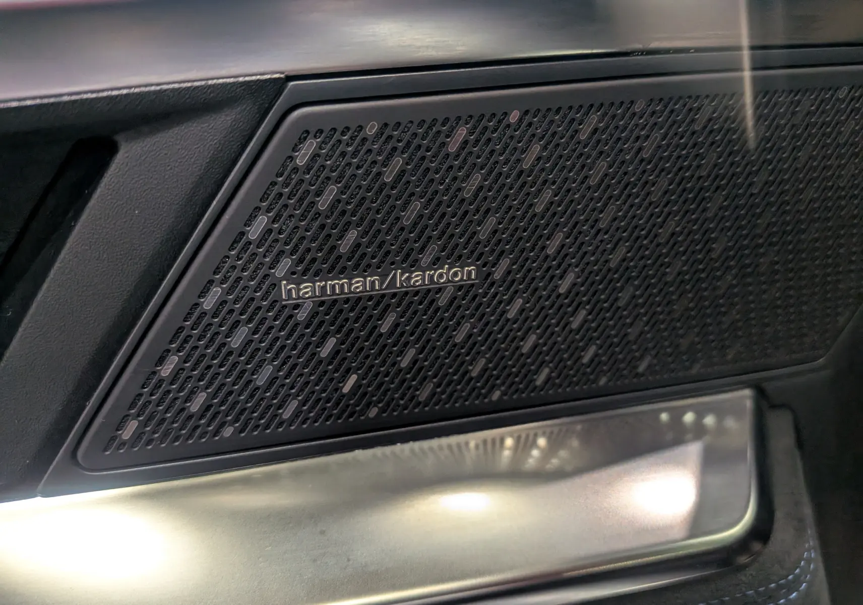Gros plan sur l'enceinte Harman Kardon intégrée dans la porte intérieure noire du Renault Austral E-Tech hybrid 2023.