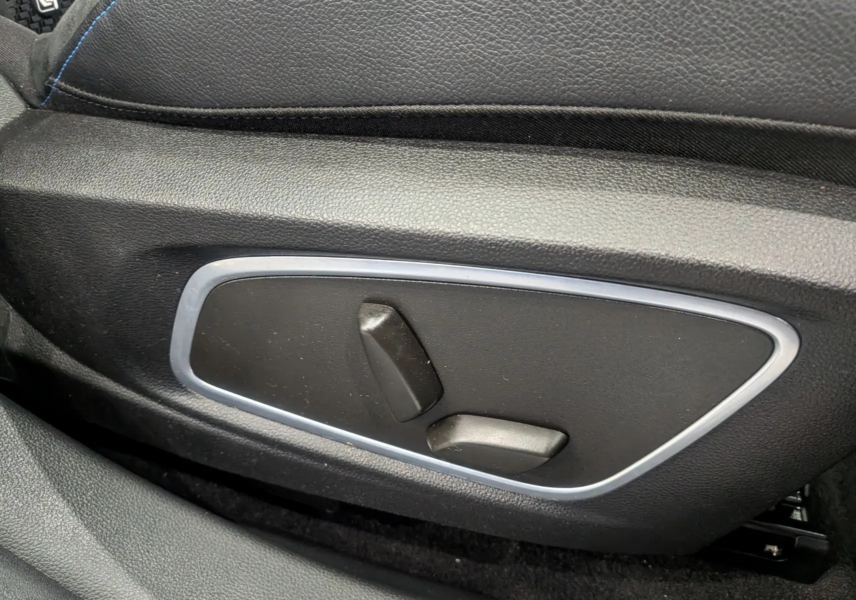 Gros plan sur les commandes de réglage électrique du siège avant noir du Renault Austral E-Tech hybrid 200 Iconic esprit Alpine.