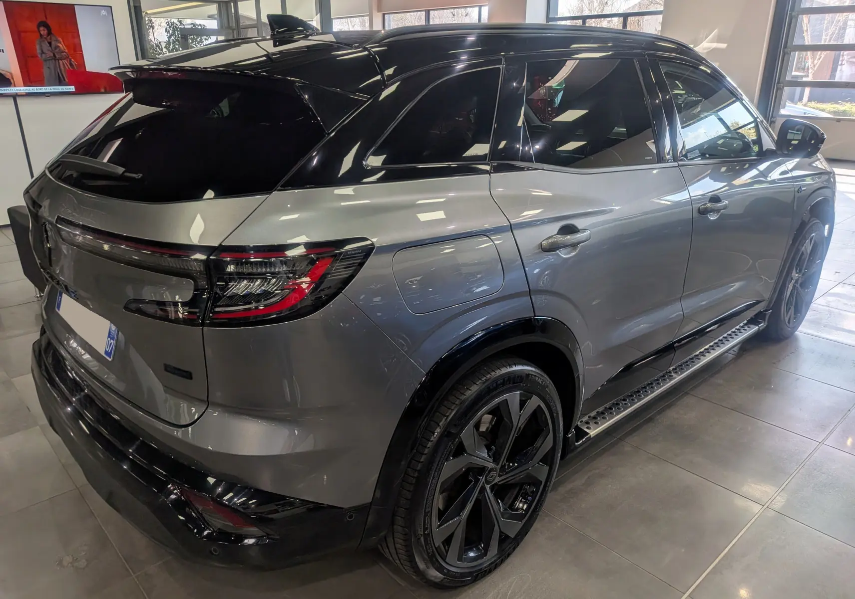 Vue 3/4 arrière droite du Renault Austral E-Tech hybride 2023 gris schiste avec toit noir et jantes noires biton.