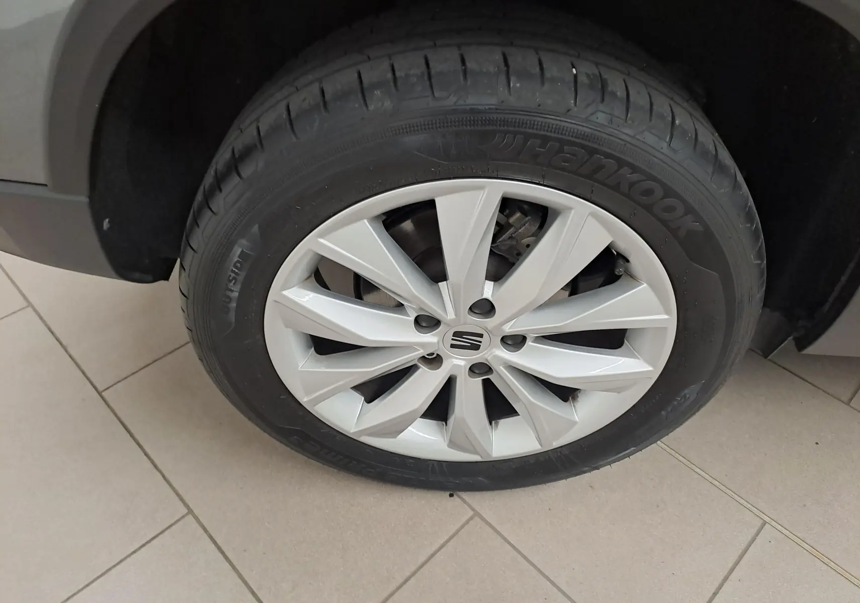 Gros plan sur la roue avant gauche du SEAT Ateca 2023 gris graphite, avec jante alliage et pneu Hankook visible.