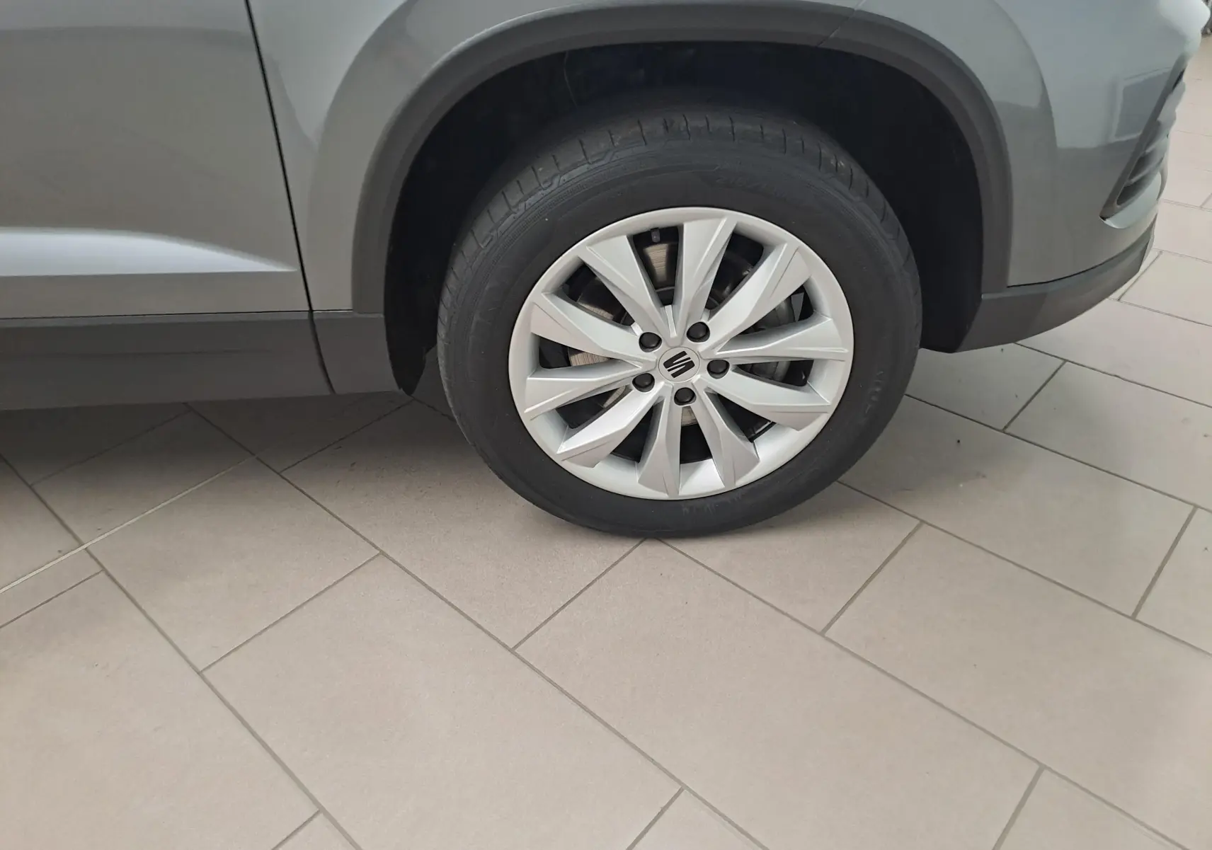 Gros plan sur la roue avant gauche du SEAT Ateca gris graphite 2023 avec jante alliage à 10 branches.