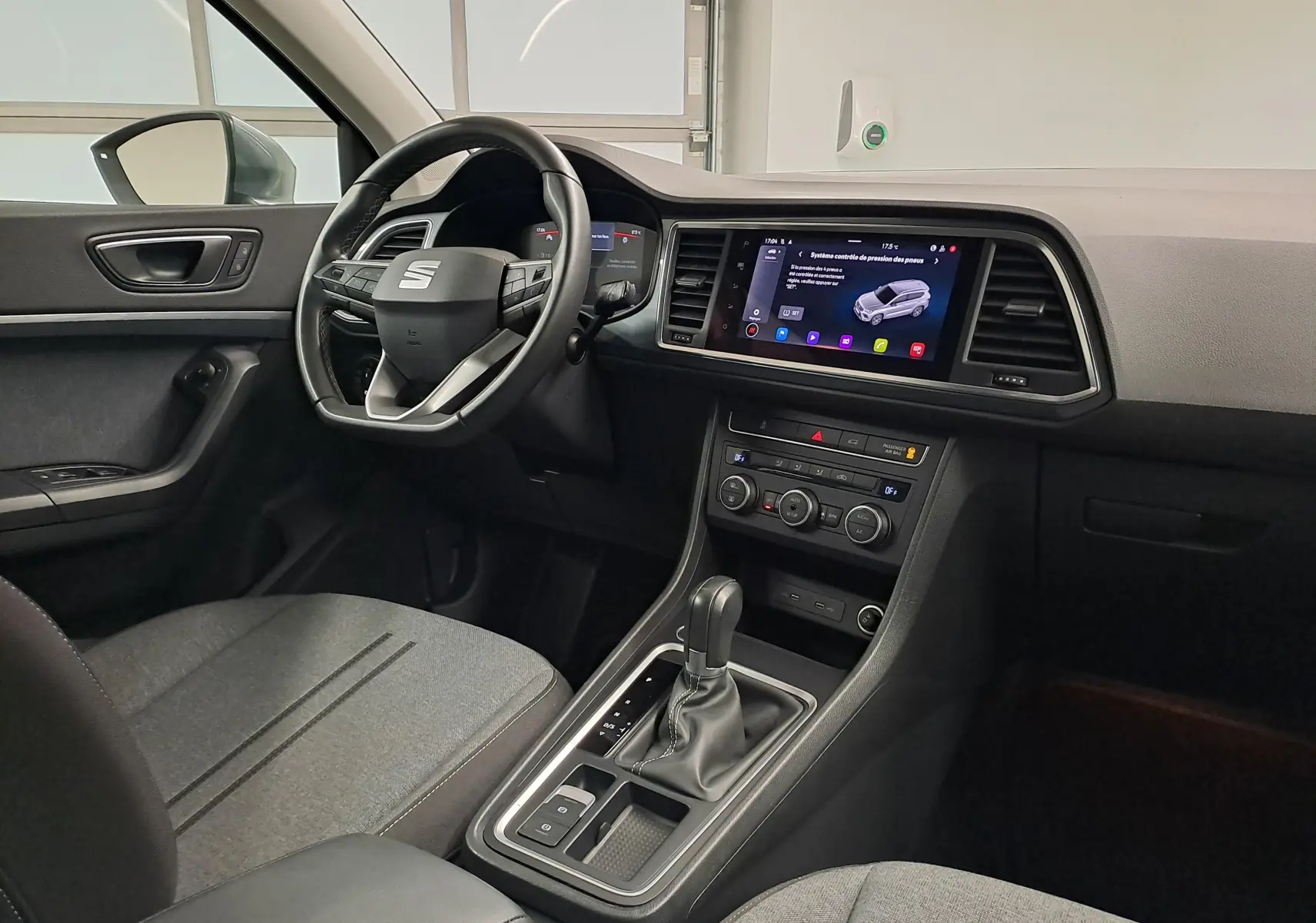 Vue intérieure côté conducteur du SEAT Ateca 2023, tableau de bord moderne avec écran tactile et volant multifonction.