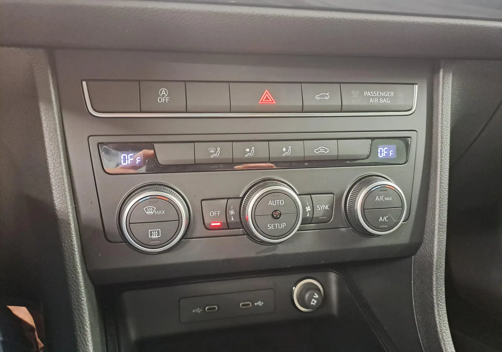 Vue rapprochée de la console centrale du SEAT Ateca 2023, montrant les commandes de climatisation et les ports USB.