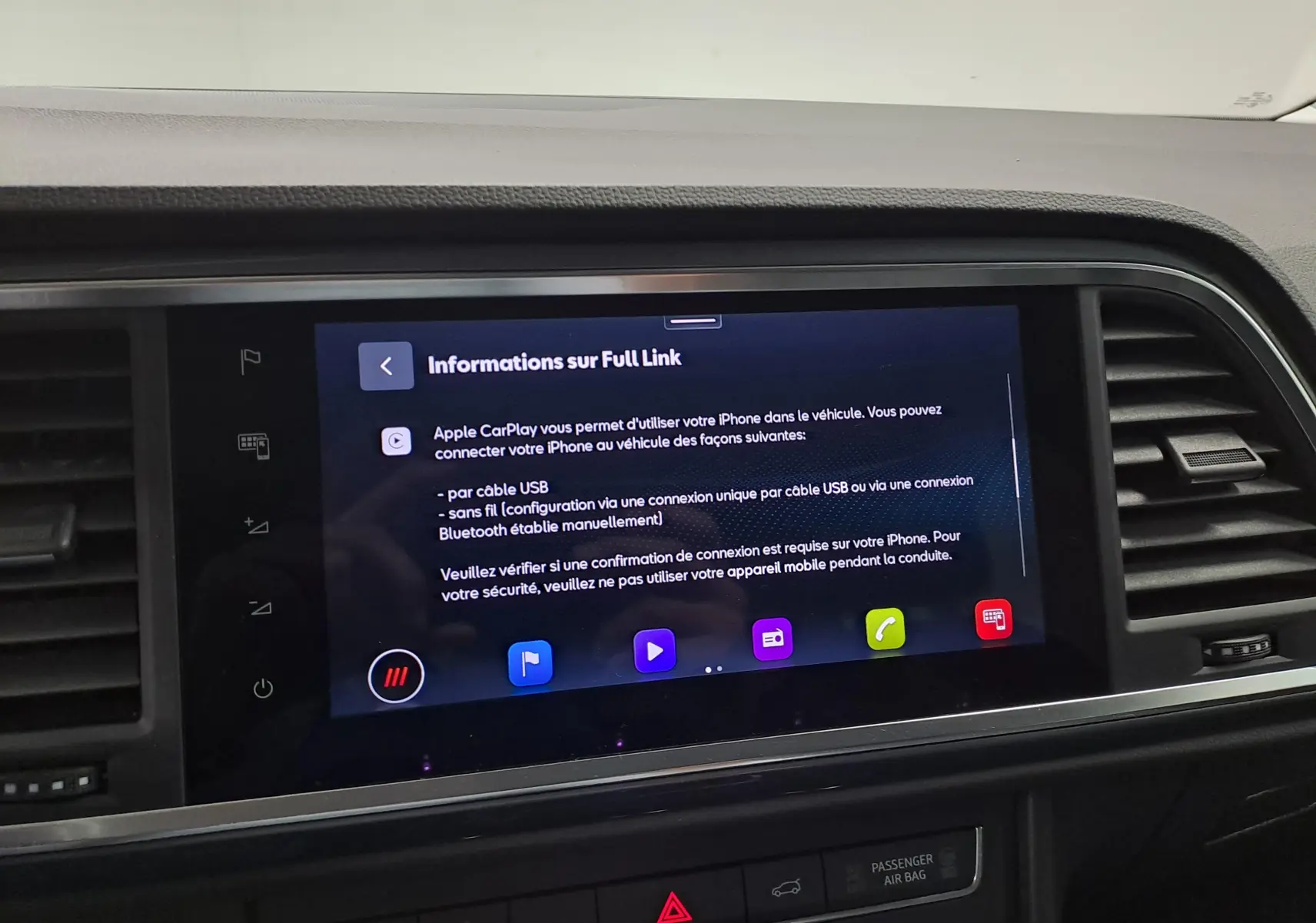 Écran tactile central du SEAT Ateca 2023 affichant les informations sur Apple CarPlay, entouré de la console noire.