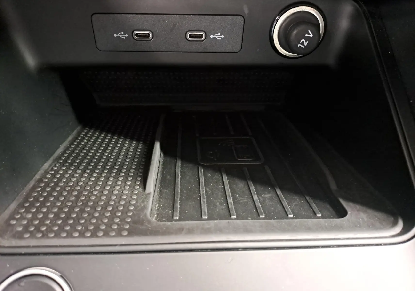 Gros plan sur la console centrale du SEAT Ateca 2023, montrant les ports USB-C et une prise 12V, zone de recharge sans fil.