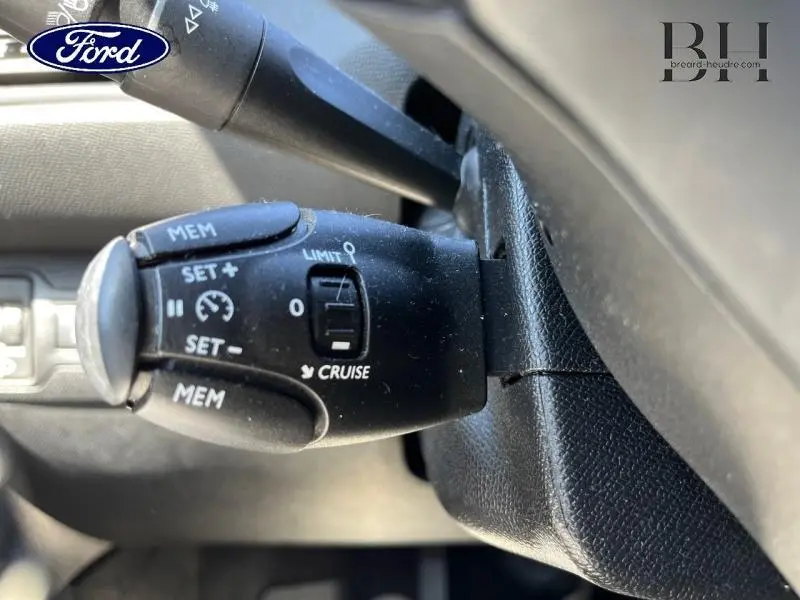 Gros plan sur la commande de régulateur de vitesse noire dans l’habitacle d’une Peugeot 308 gris Artense.