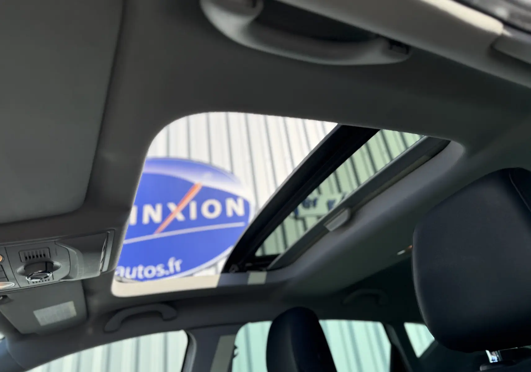 Vue intérieure du toit ouvrant panoramique du SEAT Leon 1.8 TFSI blanc de 2014, avec ciel visible à travers le verre.