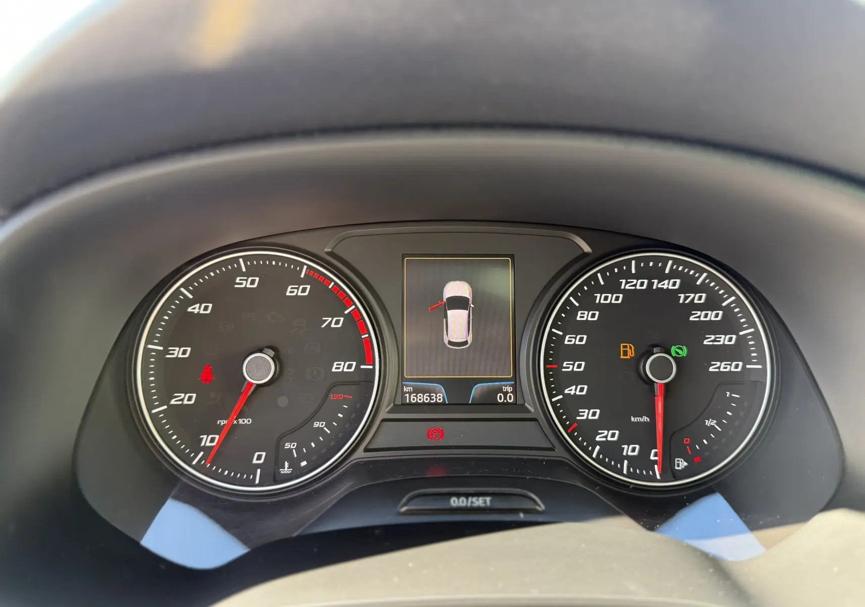 Vue rapprochée du tableau de bord du SEAT Leon 1.8 TFSI 2014 montrant compte-tours, vitesse et écran central d’alerte.