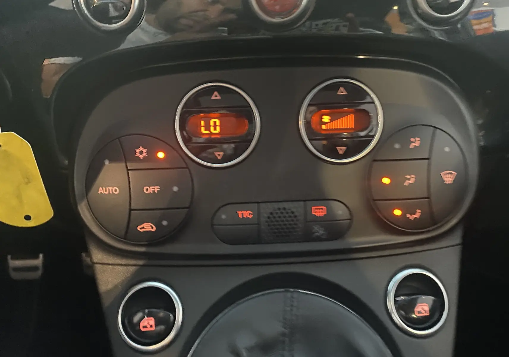 Détail du tableau de bord et commandes de climatisation automatique de l'Abarth 595 noire de 2018.